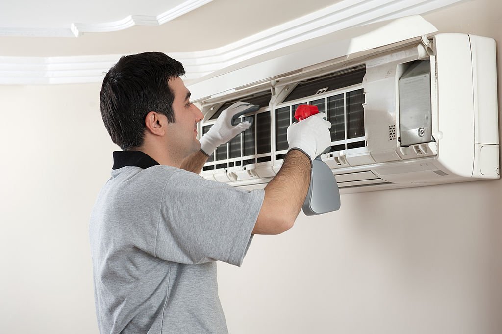 Air conditioner technician servicing indoor.